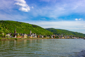 Promenade with colorful houses and Catholic Parish Church of St. Nicholas along the Rhine in Kamp-Bornhofen, Germany