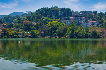 KANDY, SRI LANKA - FEBRUARY 10, 2021: View on Kandy lake and big Buddha on top of the hill. Kandy is home of The Temple of the Tooth Relic, one of the most sacred Buddhist places of worship. 