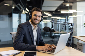 Portrait of successful businessman teacher mentor. Man in business suit records audio course...