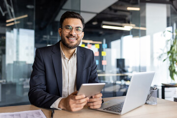 Portrait of a successful young businessman, the man is smiling and looking at the camera. The...