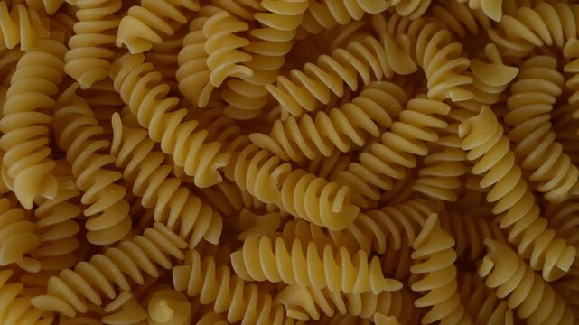 Raw Fusilli Spiral spaghetti pasta pattern background.