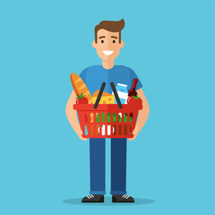 Smiling man holding a red shopping basket full of groceries © johndaly