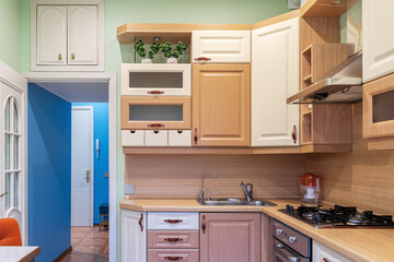 wooden built-in cupboards in kitchen. Brown furniture in kitchen. Bright kitchen furniture design....
