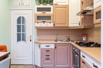 wooden built-in cupboards in kitchen. Brown furniture in kitchen. Bright kitchen furniture design....