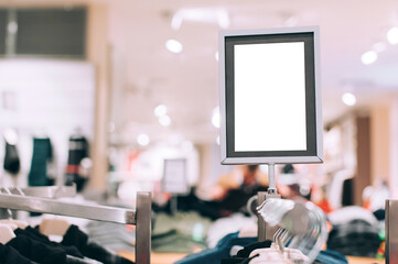 Fototapeta premium Blank silver frame sign in clothing store, blurred background.