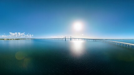 Fototapeta premium Drone panorama of the Sunshine Skyway Bridge in its full glory, arching over Tampa Bay's sparkling waters, illuminated by bright Florida sunlight. 