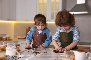 Cooking recipe. Little children cutting cookie dough with cutters at table indoors
