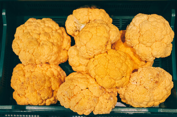 Pile of vibrant yellow cauliflower heads in a crate.
