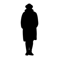 Obraz premium Silhouette of a person in a winter coat and hat standing still