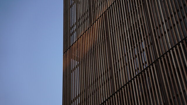 airy modern facade with wooden planks against the sky