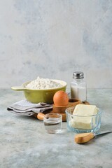 Ingredients for making shortcrust pastry on a gray concrete background. Different types of dough.