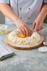 Kneading shortcrust pastry by hand on a wooden board on a grey concrete background. Different types of dough and their preparation techniques.