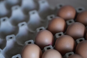 Brown chicken eggs neatly arranged in a paper tray, ready for cooking