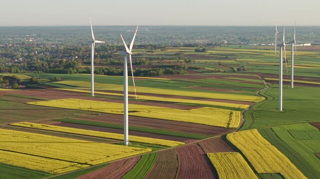 4K, aerial, DJI Air 3S, drone footage at sunrise, showing modern wind turbines producing green energy in the countryside. Ideal for topics related to sustainability, renewable energy.