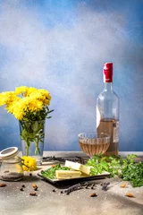 Fotobehang Eetkamer Slices of cheese with herbs, rose wine, and yellow flowers creating a relaxing atmosphere  © Victoria Kondysenko