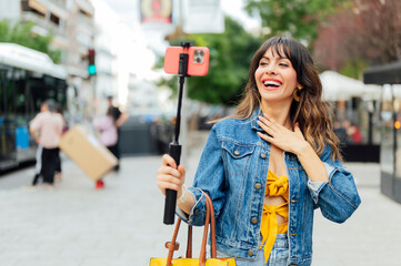 Influencer creating video content with selfie stick and smartphone in urban environment