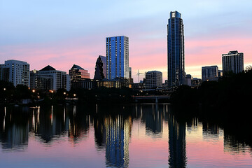 Naklejka premium City Skyline at Sunset with Water Reflection