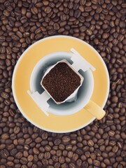 노란색 커피잔에 놓인 드립백 커피 