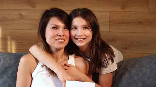Mom and daughter hugging and kissing each other on cheek. Heritage, parenting, childhood, female generation concept