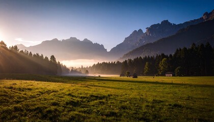 Obraz premium Paisaje de valle brumoso con campo verde y montañas brumosas; hermoso fondo de pantalla matutino; fondo pintoresco inspirador para pancartas o postales, espacio de copia, diseño de lugar, inspiración