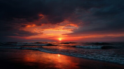 Obraz premium A dramatic orange sunset over the ocean, with the water reflecting the fiery tones of the sky and the horizon gently fading into darkness