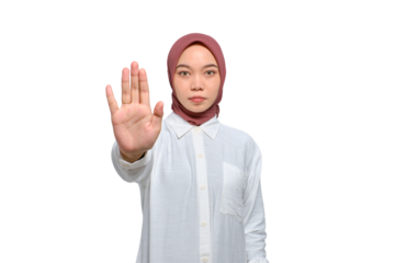 Serious young Asian Muslim woman standing with outstretched hand showing stop gesture isolated on transparent background