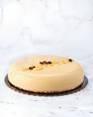 Caramel Coffee Chocolate Mousse Cake with Mirror Glaze. Front View on White Marble with Copy Space.