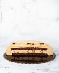 Cross-Section of Coffee Mousse Cake with Chocolate Sponge and Caramelized Pear on Marble Background.