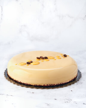 Caramel Coffee Chocolate Mousse Cake with Mirror Glaze. Front View on White Marble with Copy Space.