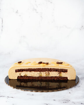 Cross-Section of Coffee Mousse Cake with Chocolate Sponge and Caramelized Pear on Marble Background.