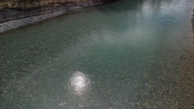 Clean shallow water Linth river Switzerland pebble stones light reflection