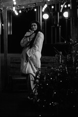 Portrait of a young beautiful dark-haired girl in the night city. Black and white photo.