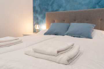 Clean white towels on bed at hotel room. Close-up. interior background. Towel in Hotel Room. Room service.