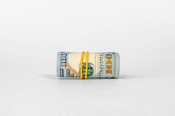 Close-up of a roll of money. On a light background.