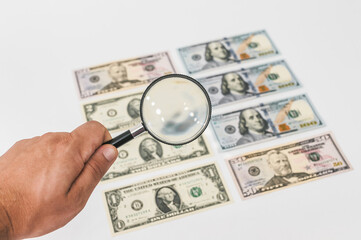 Magnifying glass on the background of dollars.