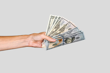 American dollars in a paper bag in the hands of a girl. On a white background.