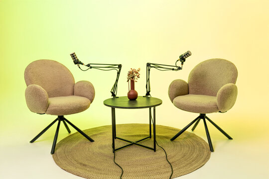 Setting for an engaging podcast interview featuring two chairs, microphones, and a decoratively arranged table