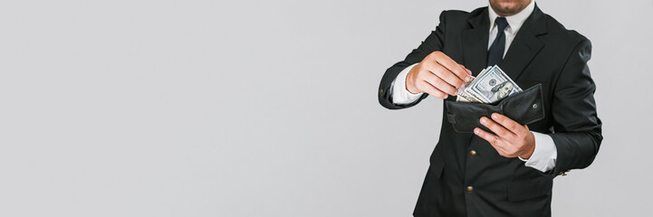 Banner, a man in a business suit gives money from a wallet on a gray-white background.