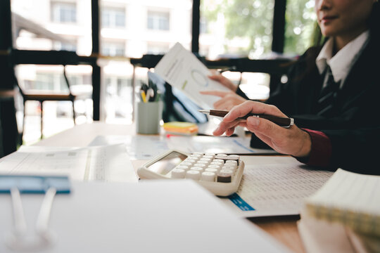 Young colleagues discussing business and price chart analyzes business people on the table great in modern coworking office teamwork concept. Calculate personal tax for customers