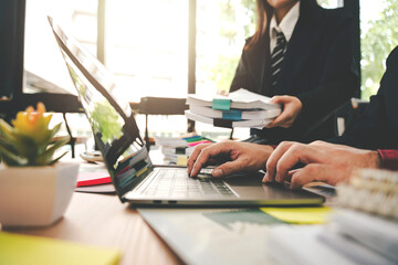 Obraz premium Employees working with a lot of documents, searching for documents, accounting for income and expenses, recording taxes, and working hard.