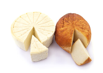 Two heads of homemade cheese and cut pieces.