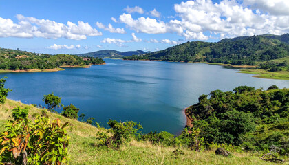 Panoramic view of a serene lake surrounded by green hills, capturing the peaceful natural landscapes of El Salvador.