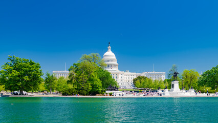 The U.S. Capitol, viewed from the west in front of the reflecting pool. The Capitol is surrounded...