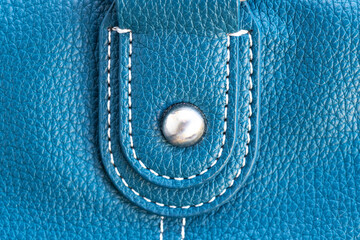 Blue leather patch with rivets on bag for attaching strap. Close-up.