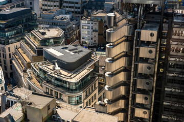 Aerial view of compact urban buildings with a mix of concrete and glass, capturing complexity and layers of vertical city growth and modern infrastructure.