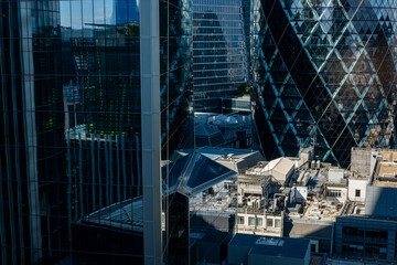 Glass buildings and rooftops intersect with iconic towers in a compact urban setting, emphasizing architectural contrast, scale and metropolitan development.