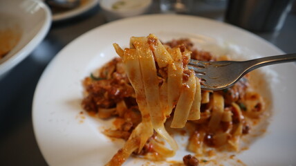 포크로 한 입 떠올린 이탈리안 미트소스 탈리아텔레 파스타 클로즈업