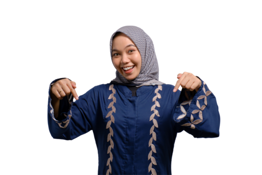Cheerful young Asian Muslim woman pointing fingers down, showing free place for advertisement isolated on transparent background