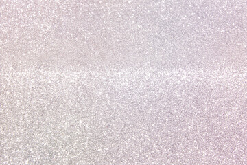 Shiny light pearlescent background made of fine glitter dust. Light festive background for wedding,