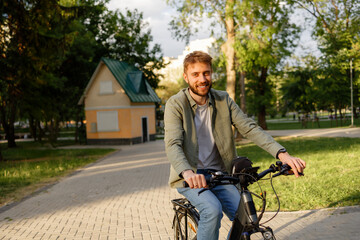 Obraz premium Young man enjoys cycling in a peaceful park during the afternoon sunlight